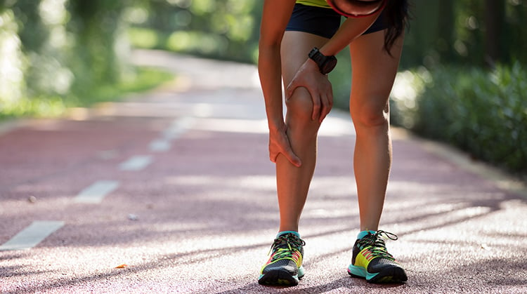 Runner on path holding shin