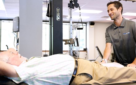 A physical therapist using manual therapy on a patient's leg.