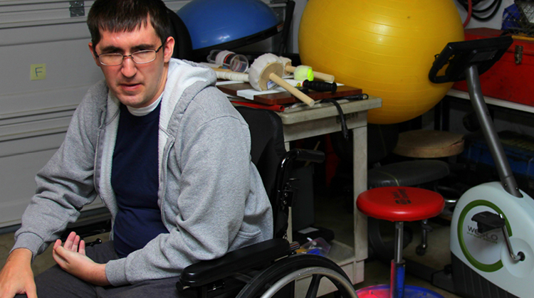 Aaron, sitting in his wheelchair in a physical therapy clinic