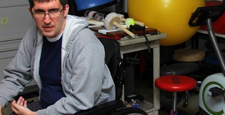 Aaron, sitting in his wheelchair in a physical therapy clinic