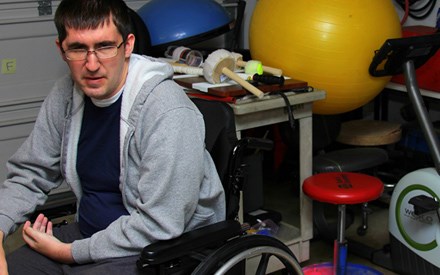 Aaron, sitting in his wheelchair in a physical therapy clinic