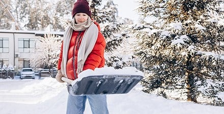 A woman shoveling snow
