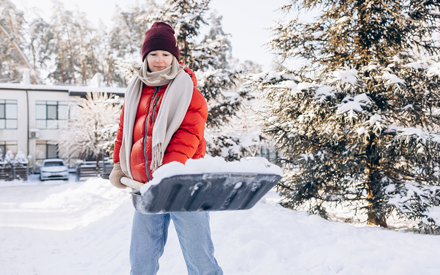 A woman shoveling snow