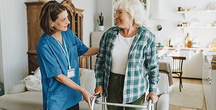 A PT helps show a patient safe use of a walker 