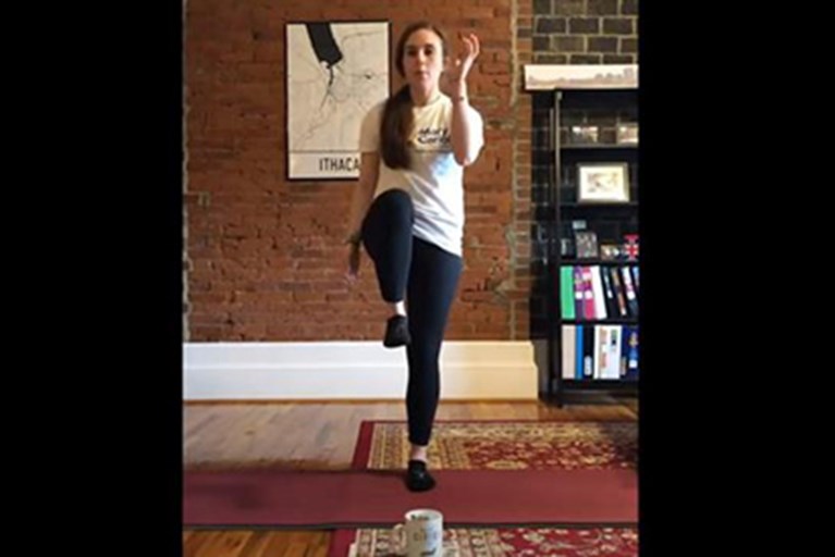 A physical therapist demonstrates "pick a popsicle stick" fun game for physical activity.
