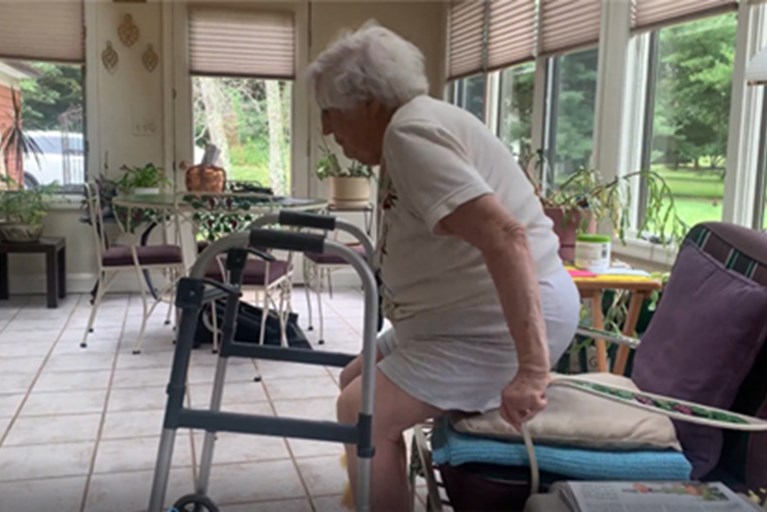 An older adult demonstrates the sit-to-stand exercise.