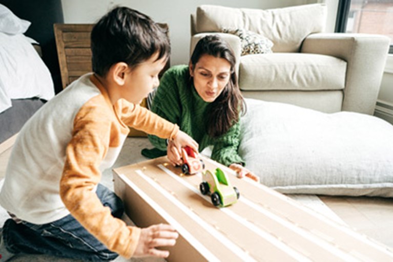Boy and mom play together pushing cars