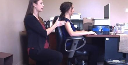 A physical therapist demonstrates proper office work station set up.