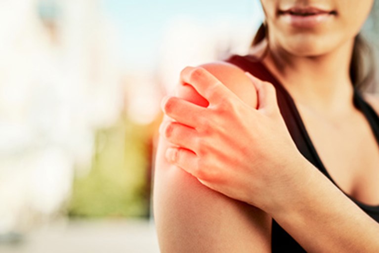 Woman holding shoulder in pain.