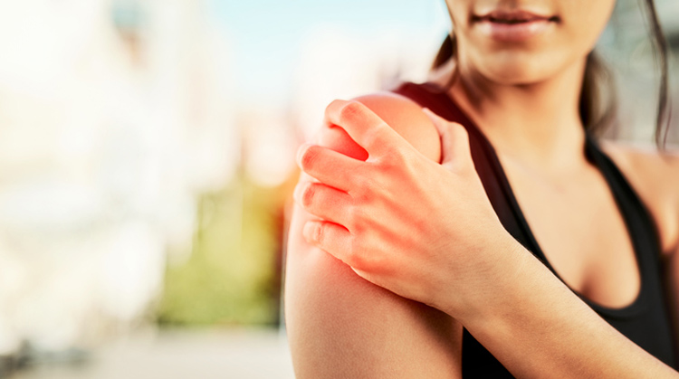 Woman holding shoulder in pain.