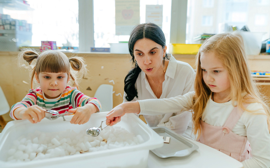 Children using tongs to pick up packing peanuts.