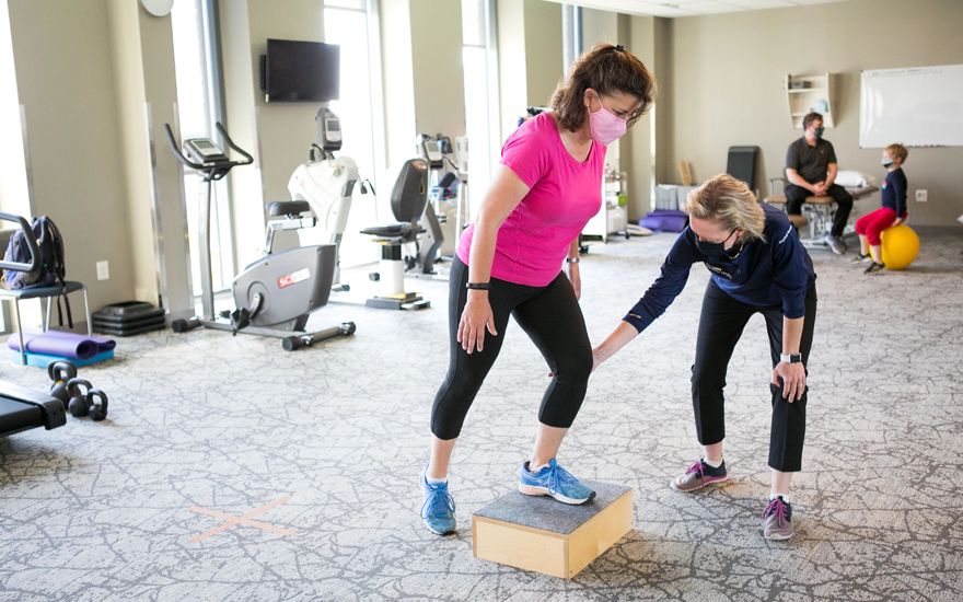 Physical therapist working with a patient on lower body exercises.