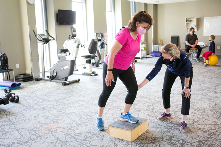 Physical therapist working with a patient on lower body exercises.