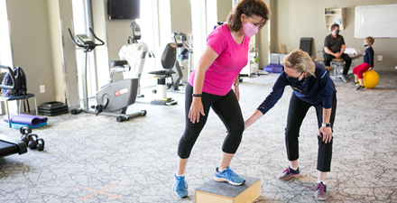 Physical therapist working with a patient on lower body exercises.