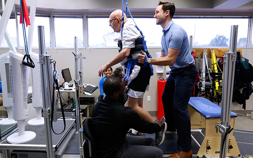 A physical therapist working with an older adult on gait training