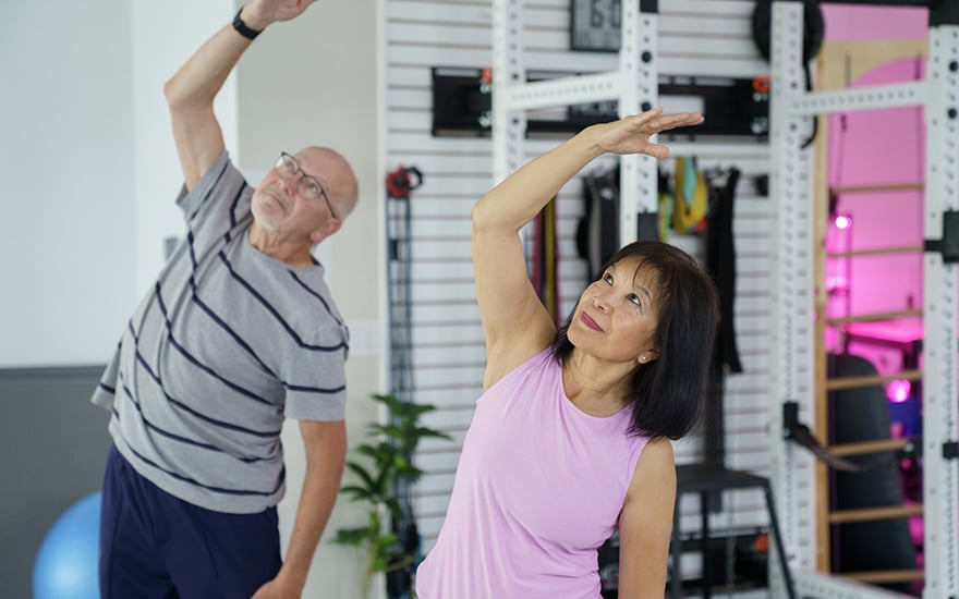 A man and woman doing gentle stretching exercises