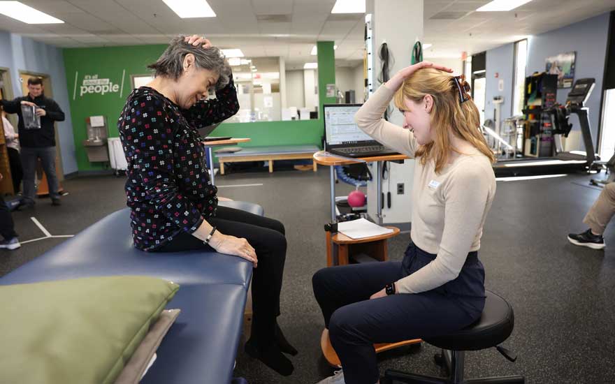 A physical therapist teaching a patient a neck exercises.