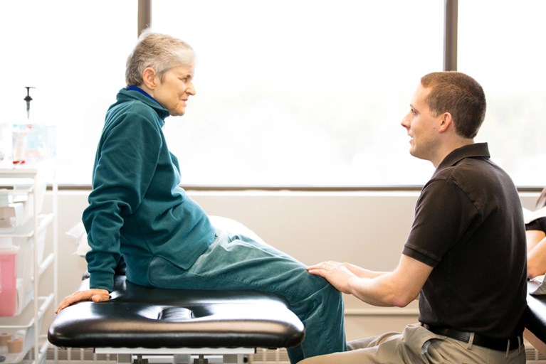 An older adult getting an assessment from a physical therapist