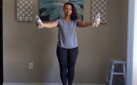 A physical therapist demonstrating upper body strengthening exercises using household items.