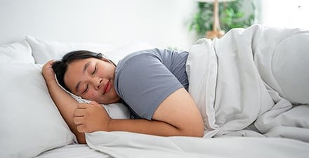 A woman sleeping on a comfortable mattress