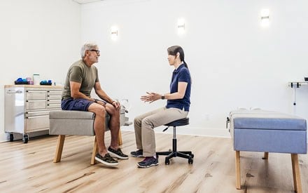 A physical therapist discusses healthy footwear with a client.