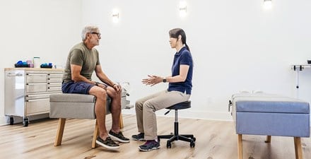 A physical therapist discusses healthy footwear with a client.