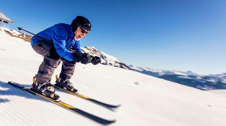 Middle-aged man skiing downhill.