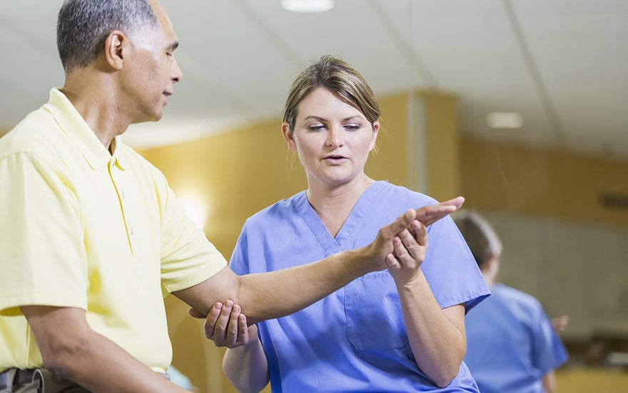 A physical therapist treating a person with inner elbow pain.