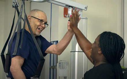 A physical therapist gives a high five to her patient during treatment for stroke.