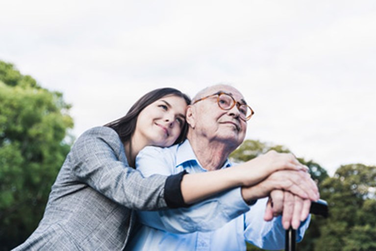 Older adult male with caregiver enjoying the outdoors.
