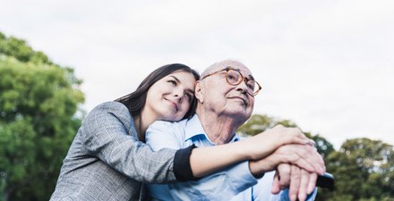 Older adult male with caregiver enjoying the outdoors.