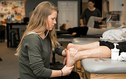A physical therapist treats a patient's food and ankle