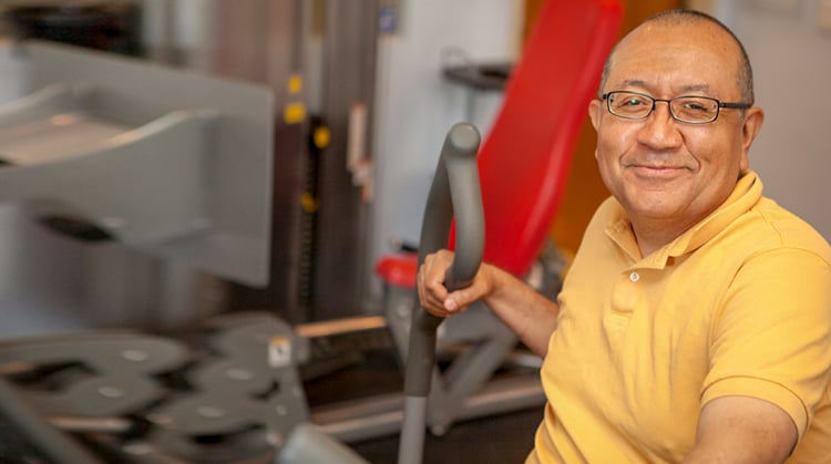 Roberto using strengthing equipment during physical therapy