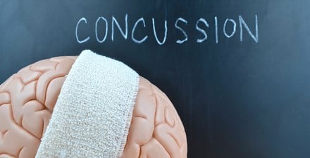 A brain with a bandage and the word concussion spelled out.
