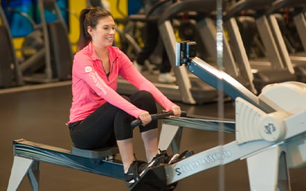 A young woman using a rowing machine.