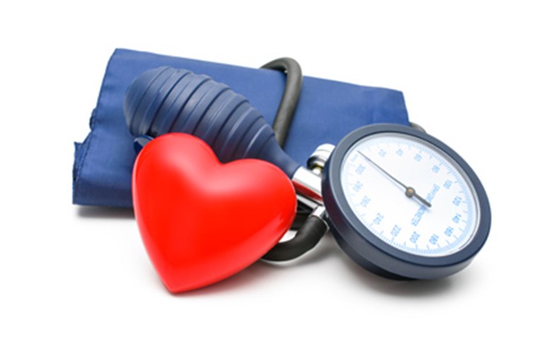 A heart next to a blood pressure cuff.