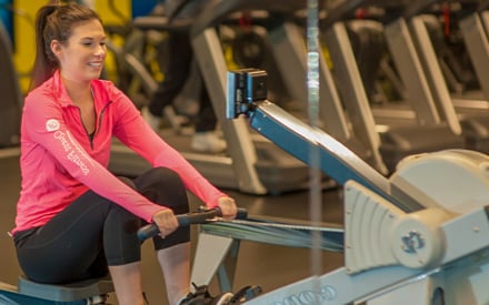 Elizabeth, riding a rowing machine.