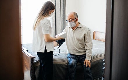 A physical therapists takes a patient's blood pressure.