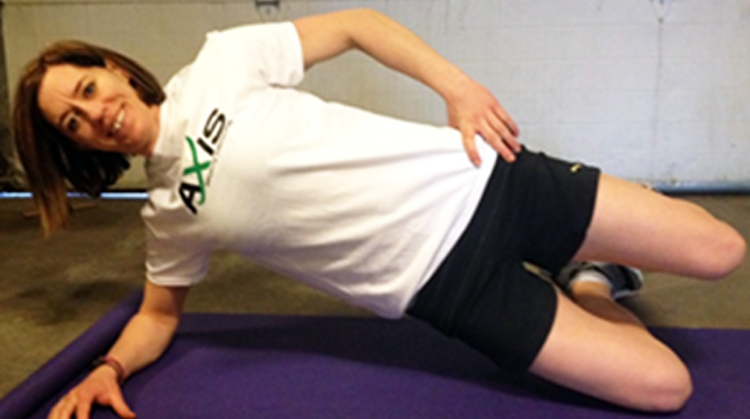 A physical therapist demonstrating a side plank exercise.