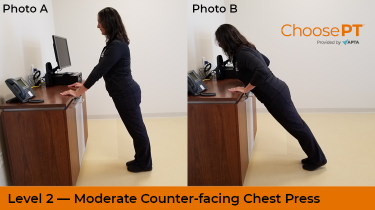A physical therapist demonstrates a counter-facing chest press exercise