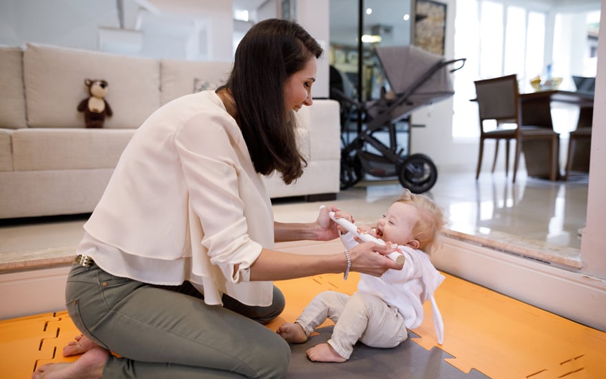 A physical therapist works with an infant with low muscle tone on development of motor skills.