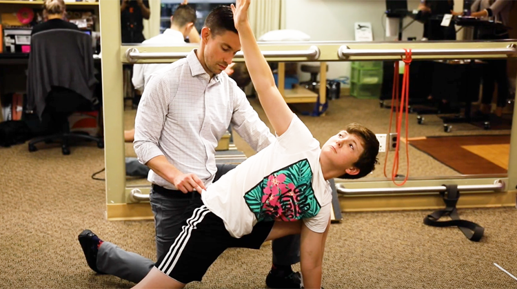 A physical therapist working with a young athlete