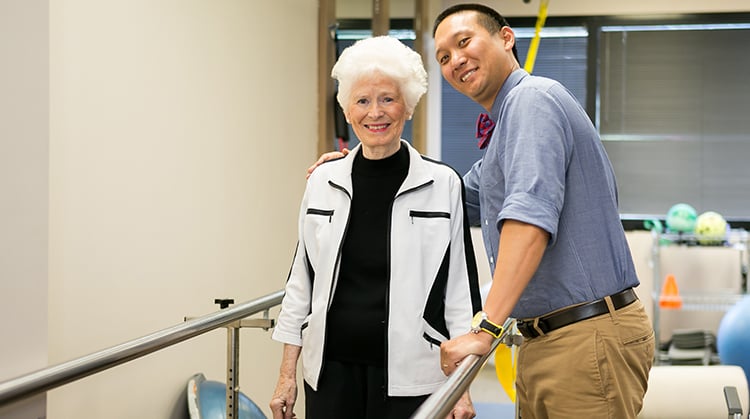 An older adult working with a physical therapist