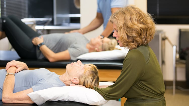 A physical therapist beginning a maneuvre to address benign paroxismal positional vertigo.