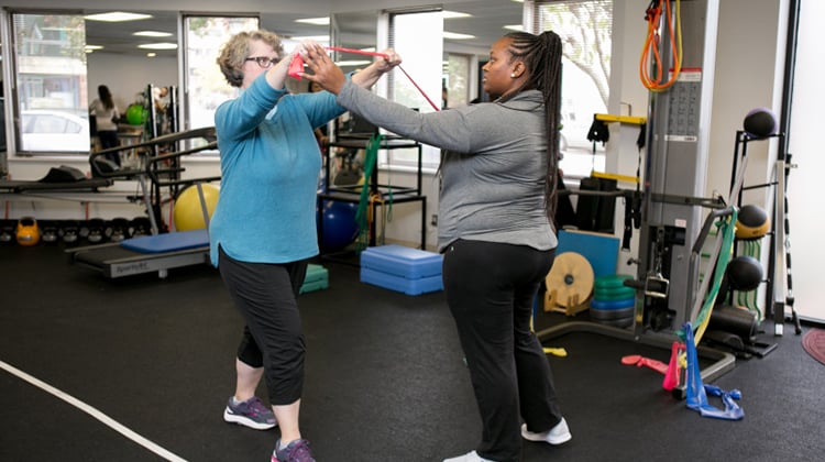 A physical therapist working with a patient on strengthening exercises