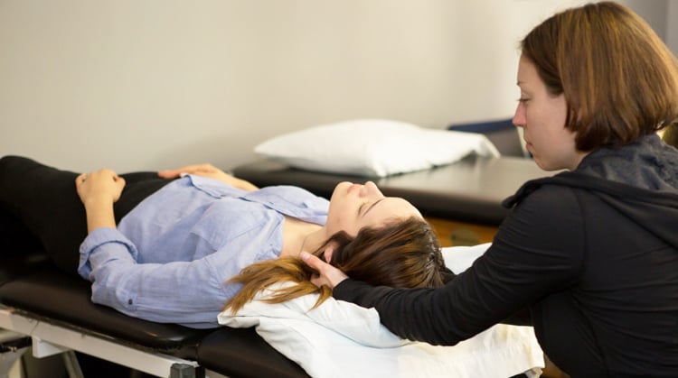 A physical therapist using manual therapy on a patient's neck