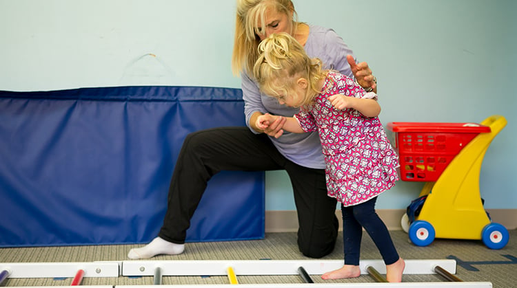 A physical therapist working with a young child