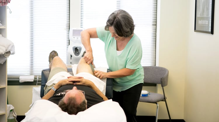 A physical therapist working with a patient in the clinic