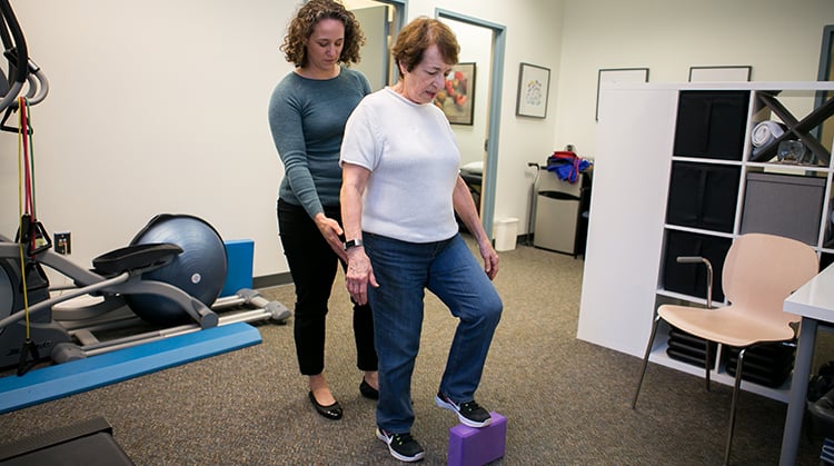 A physical therapist working with a patient on movement and balance skills