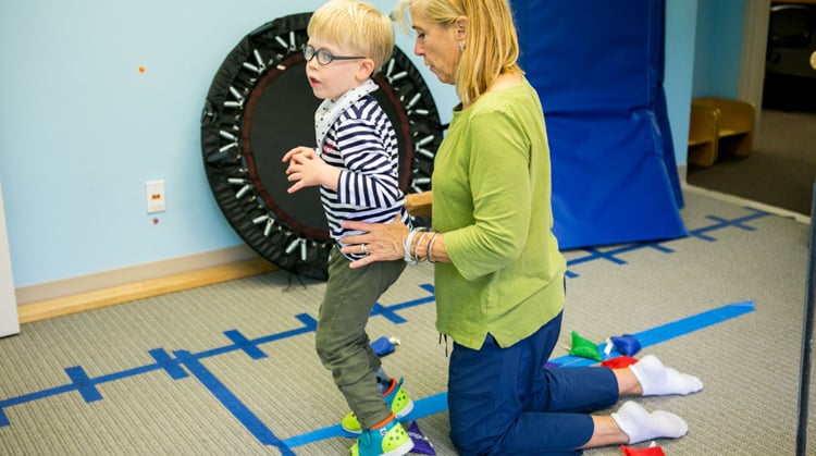 A physical therapist working with a child.